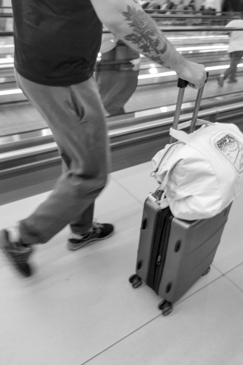 Off-White Duffle Bag With Plane and Moon Illustration on an airport